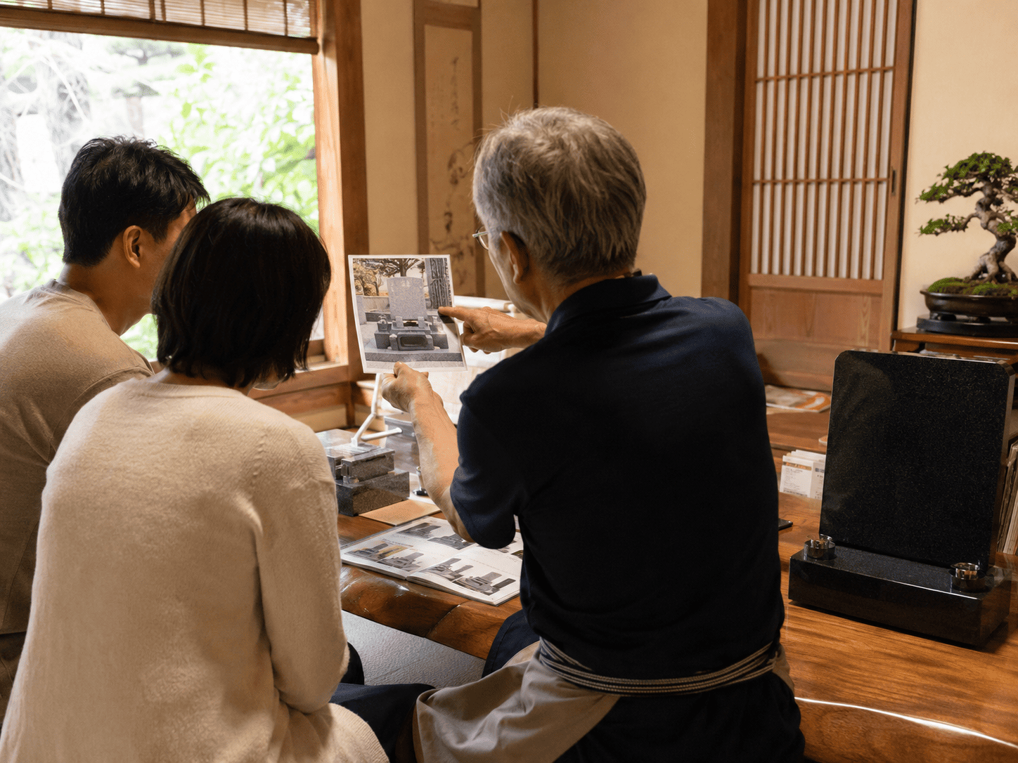 戒名追加彫刻のよくある不安について石材店で相談するご家族の様子