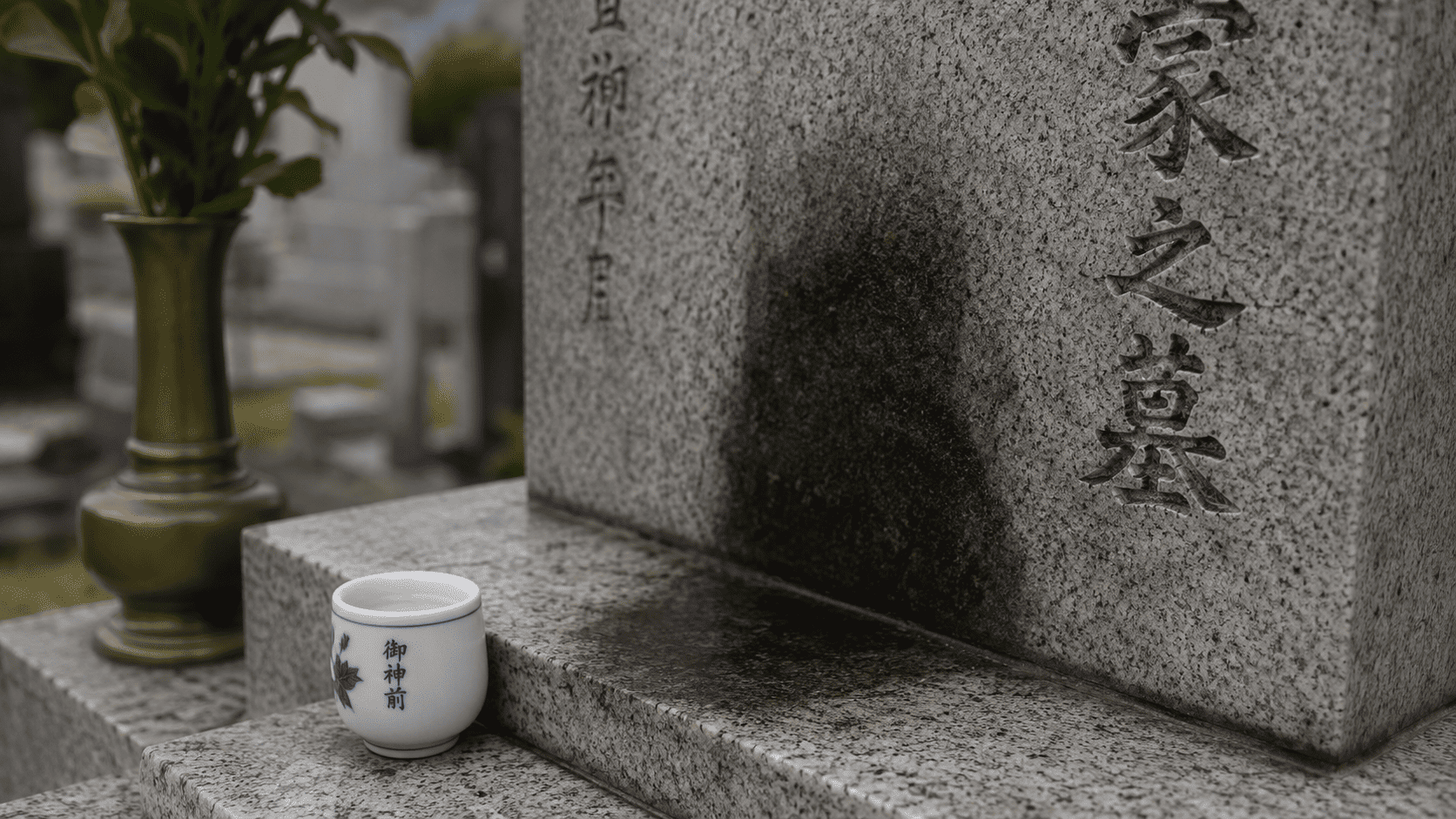墓石の表面に残った黒ずみと石内部まで染み込んだシミの違いを示すクローズアップ
